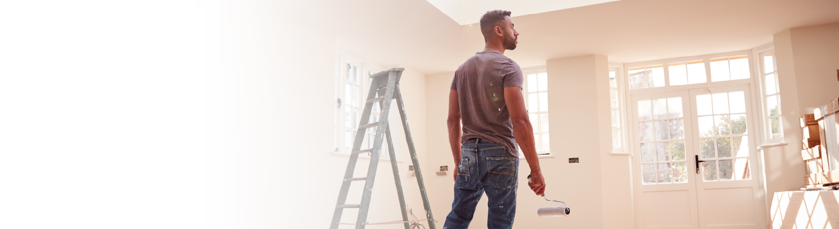 Man holding paint brush in living room.